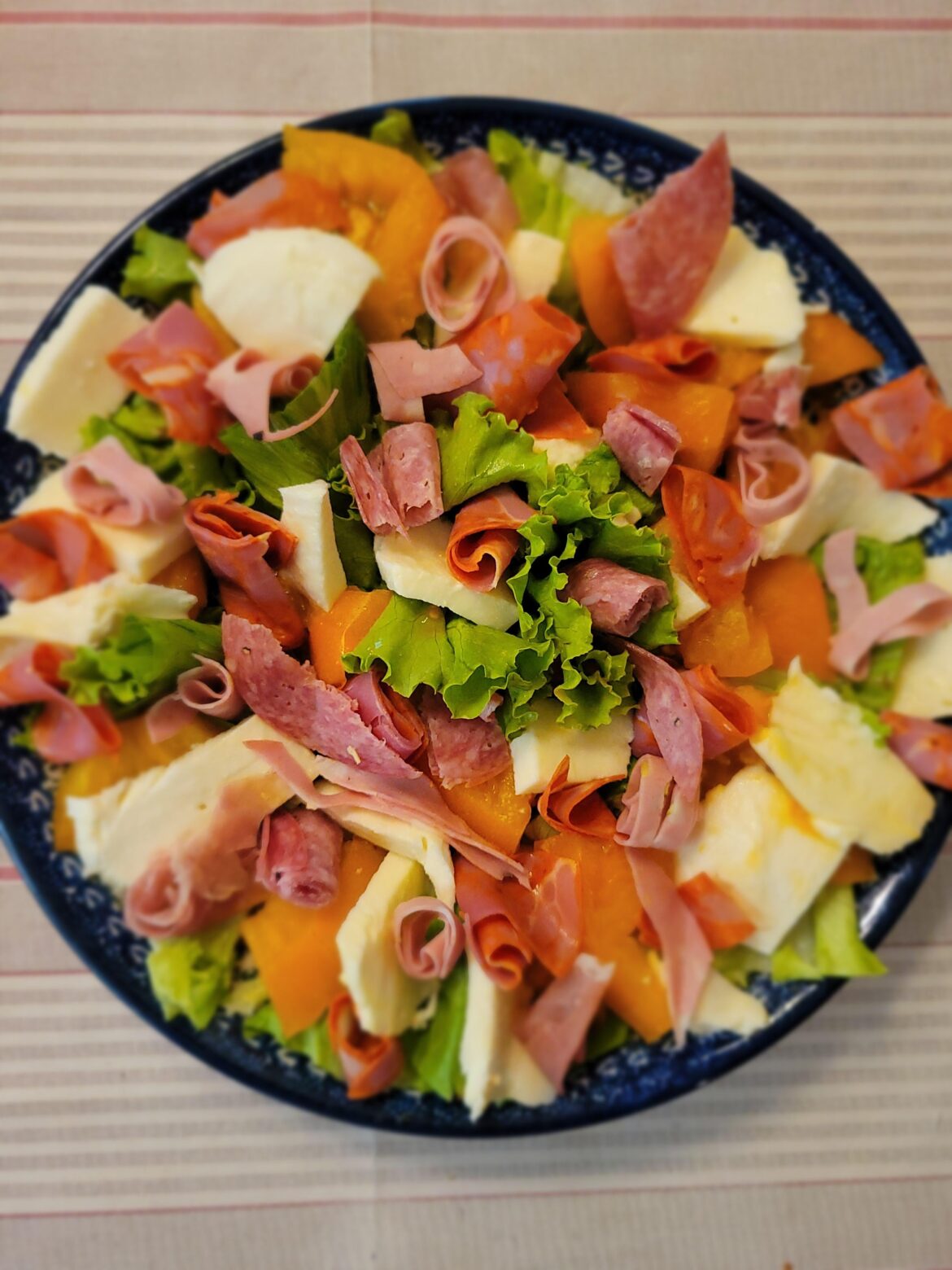 Antipasta salad with prosciutto, mozzarella, bib lettuce, orange tomatoes, salami, capicola, and mortadella