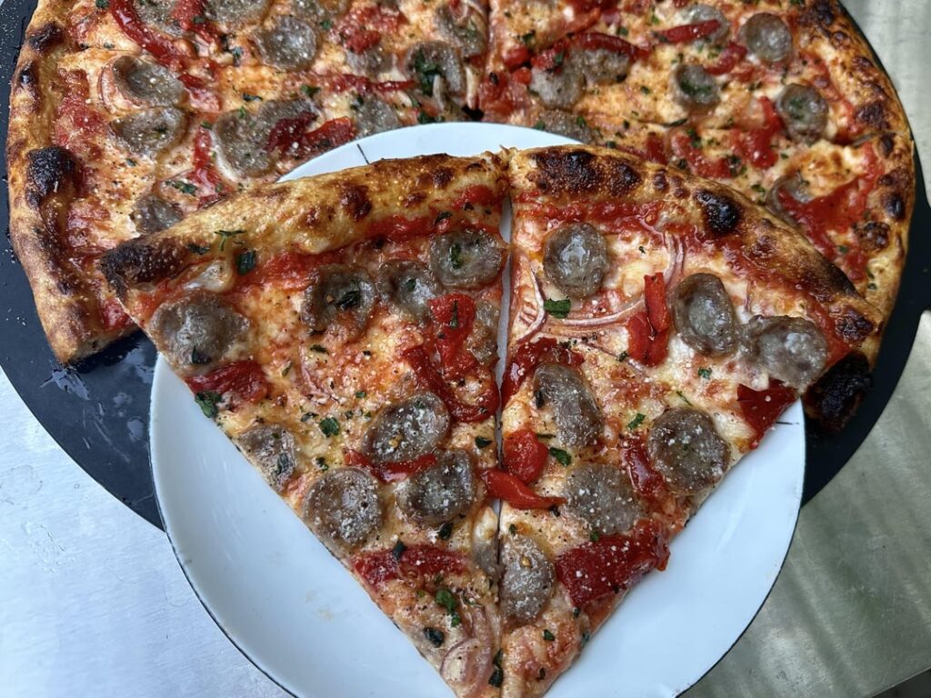 Homemade pizza with sausage, onions, and peppers