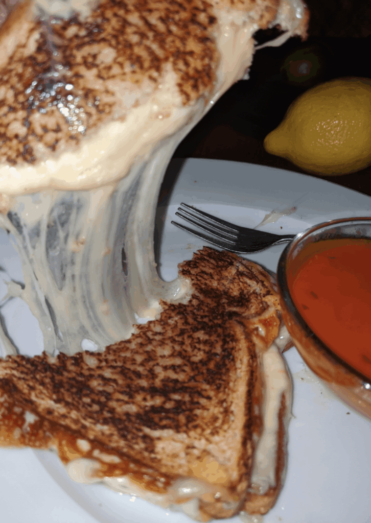 Havarti, Gouda, and Wisconsin Cheddar mixed on toasted honey wheat, w/side of sweet basil tomato soup. 🤤