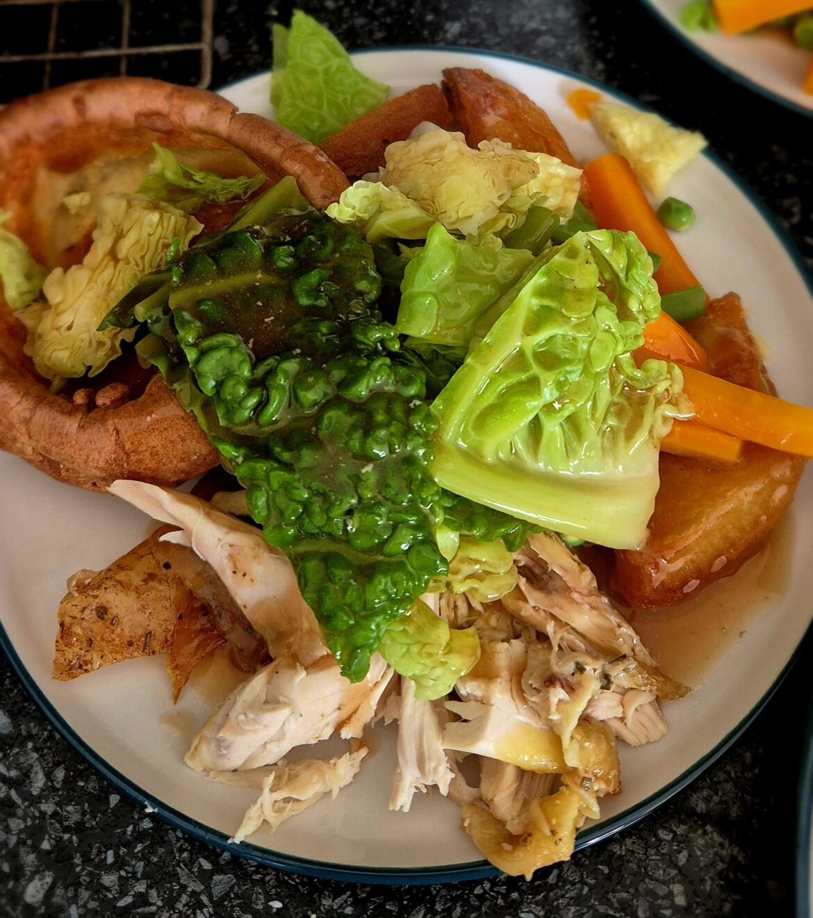 Roast chicken, roast potatoes, carrots, cabbage, hand shelled peas and yorkshire