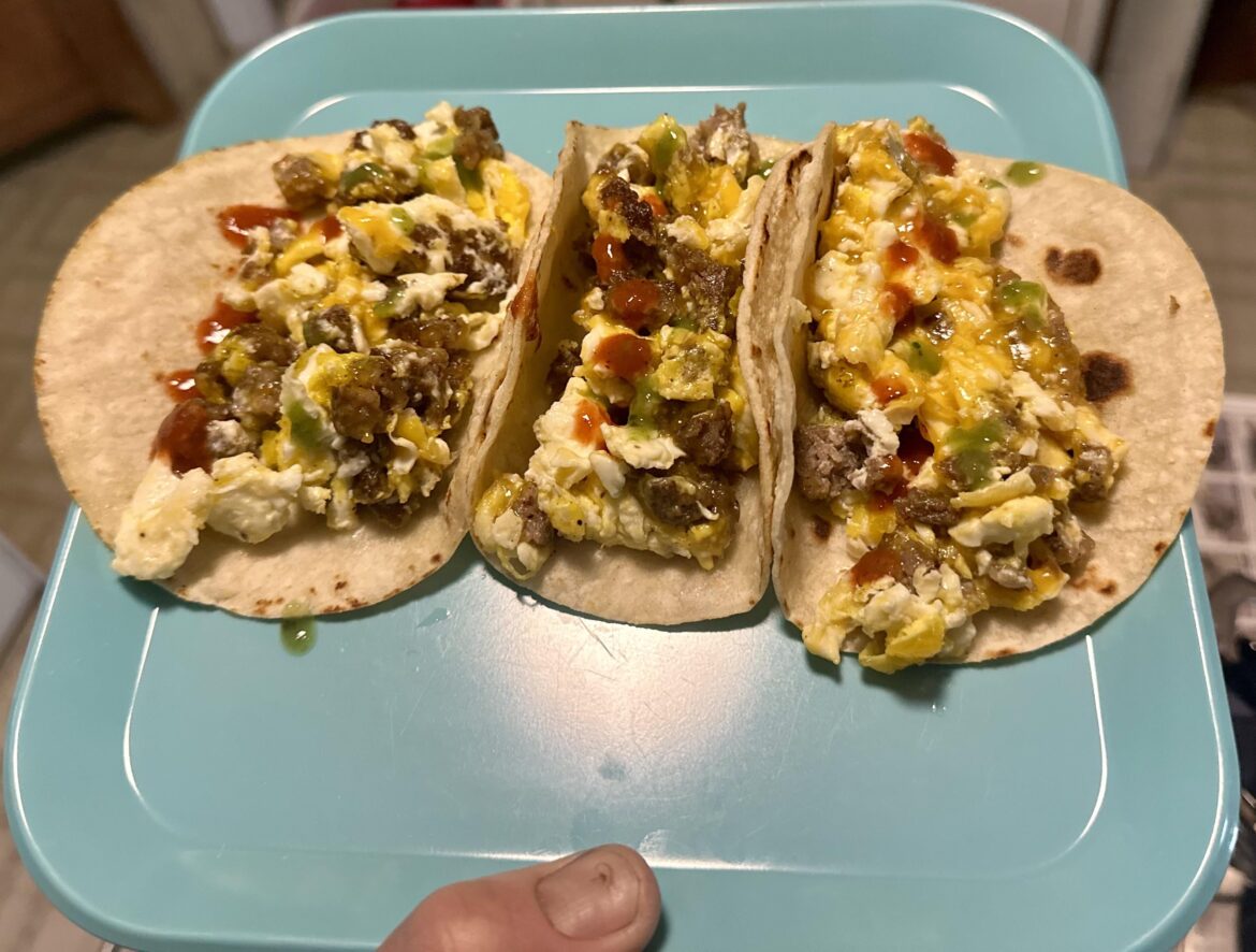 Sausage, egg, and cheese breakfast tacos with green and red habanero sauce