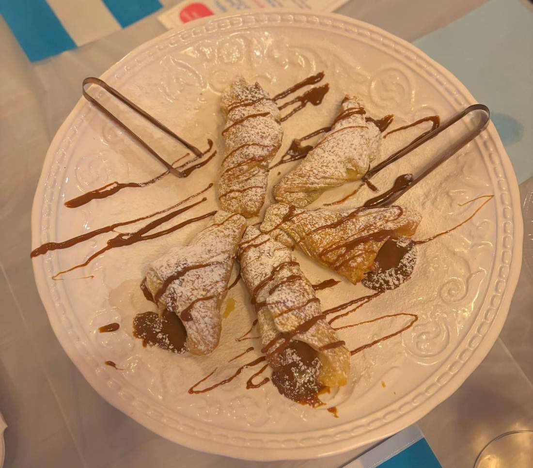 half crescent pastries with powdered sugar and dulce de leche.