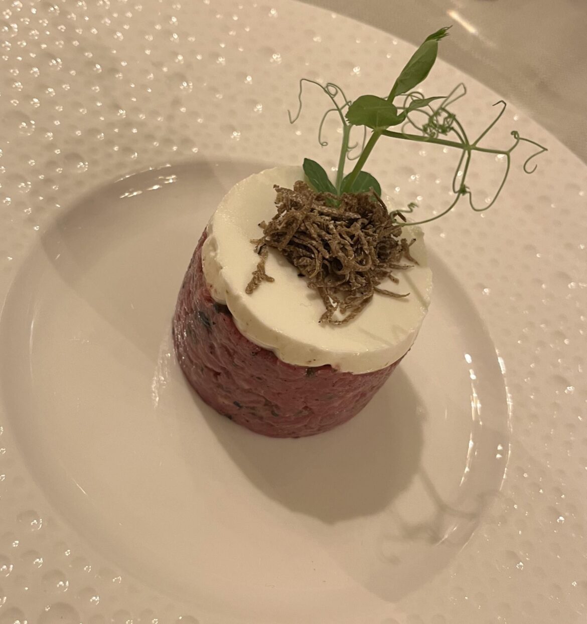 Beef tartar with bits of fresh figs and black peppercorns, goat cream cheese and shaved truffles on top