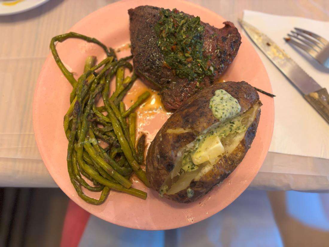 a steak with asparagus and a baked potato.
