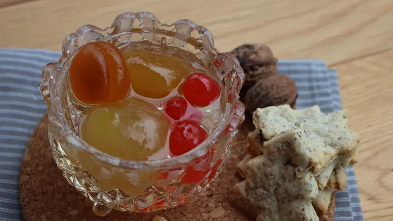 Cup of mostarda with crackers on a wooden table
