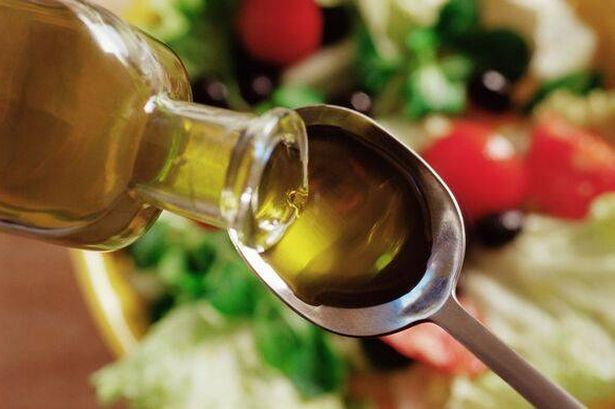 Olive oil pouring on to a spoon