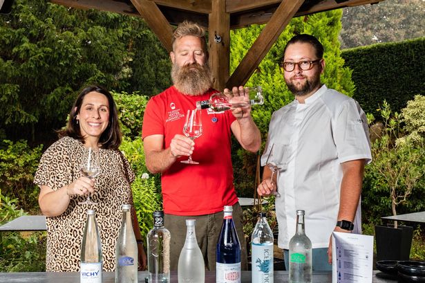 Three people holding a glass of water