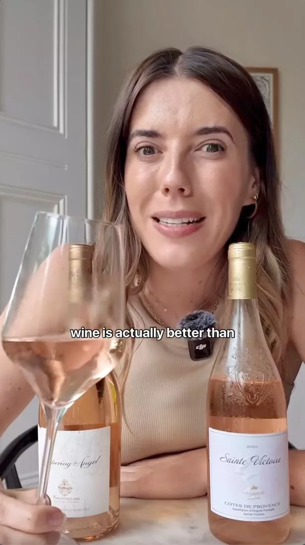 A picture of Lucy Hitchcock with two bottles of rose in front of her