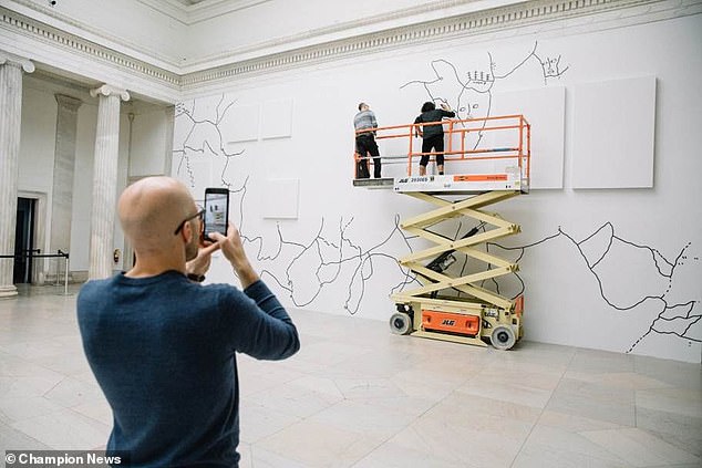 Ms Martin at work on one her designs, which are often drawn on a huge scale and incorporate text, map-like landscapes and human faces