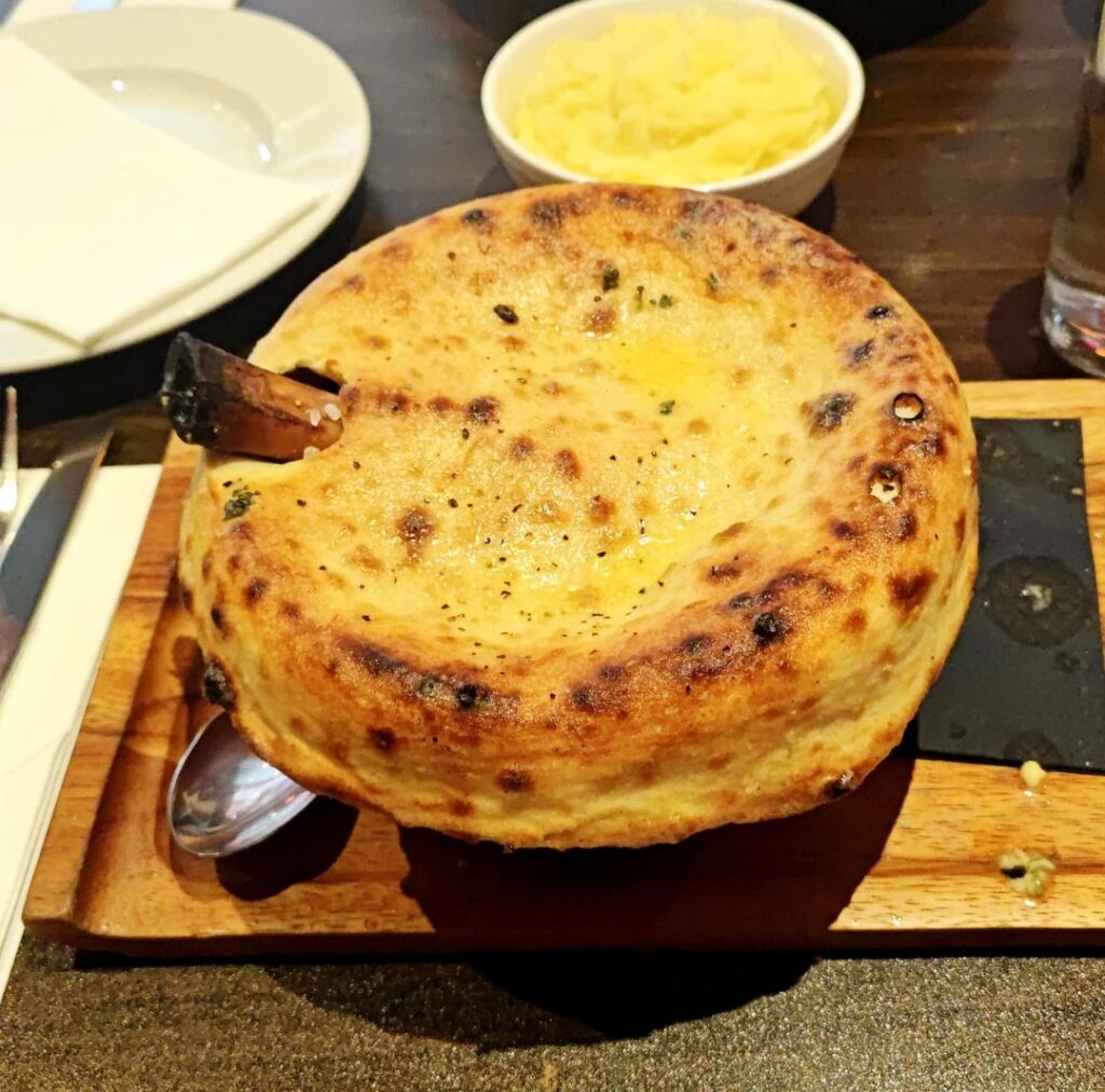 Clay pot lamb shank stew with garlic butter naan crust, and side of mash potatoe
