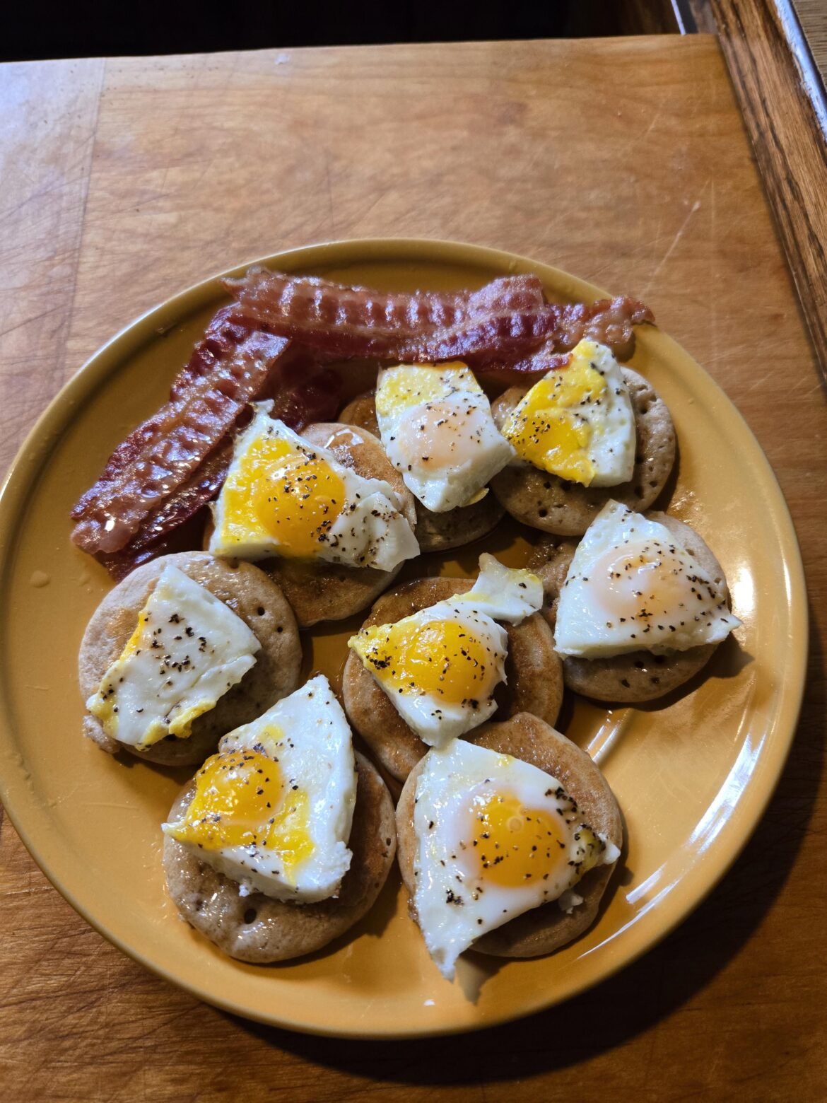 Quail eggs on mini pancakes and bacon