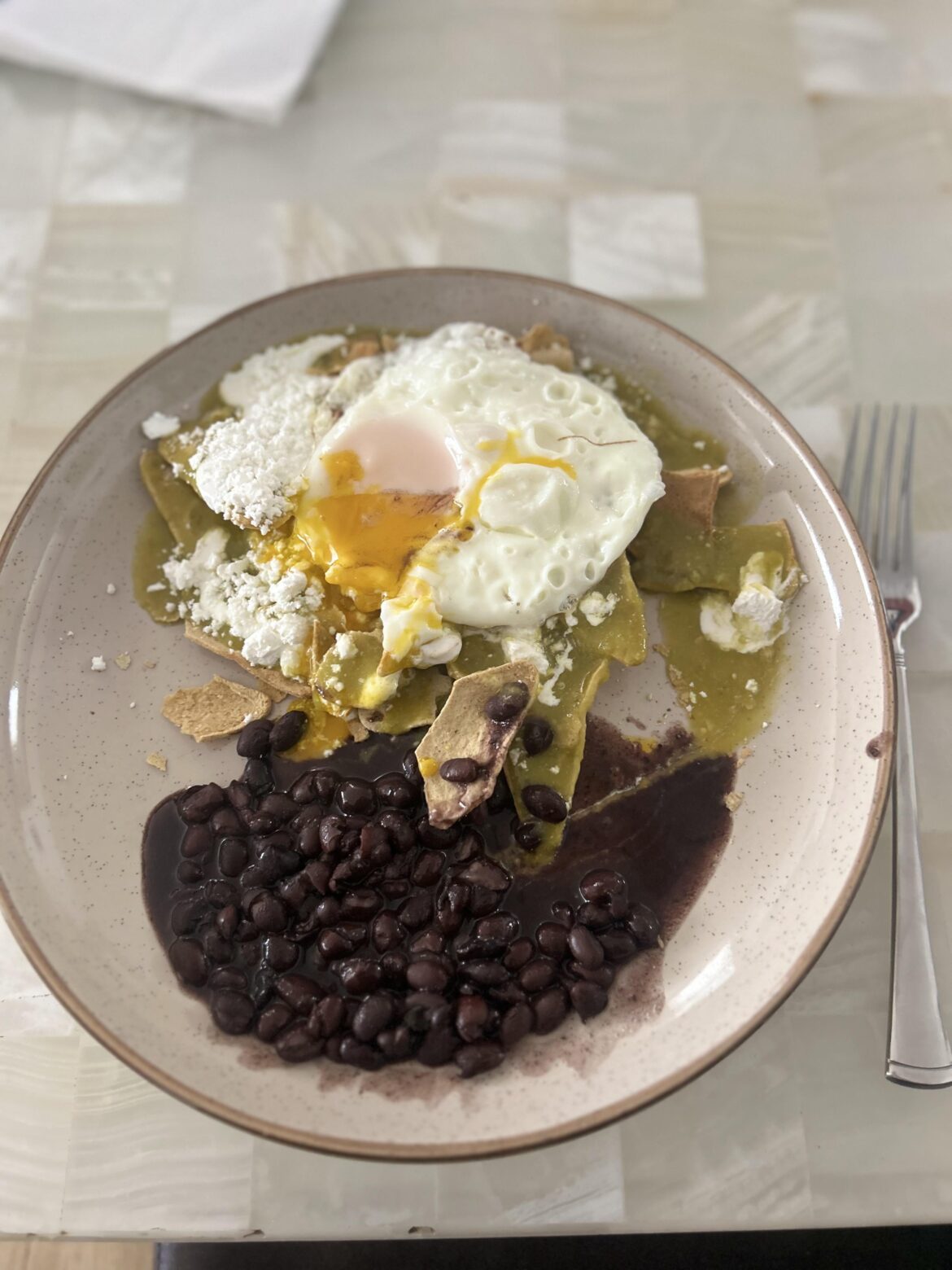 Green chilaquiles with black beans and egg