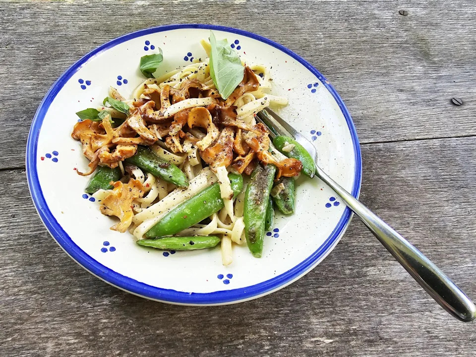 Pasta with peas and golden chanterelles.