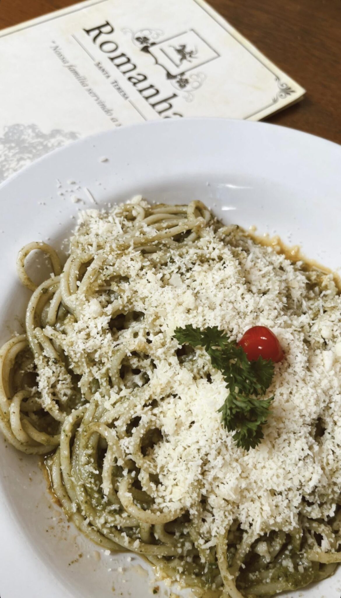 Pesto spaghetti topped with parmesan