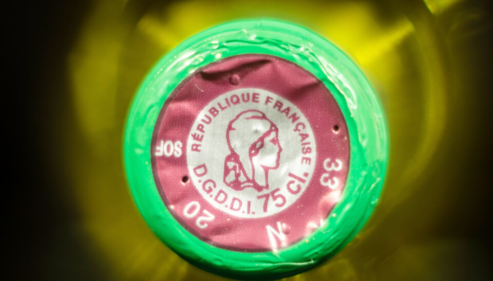 Selective blur on the marianne sign on a bordeaux bottle of white wine.