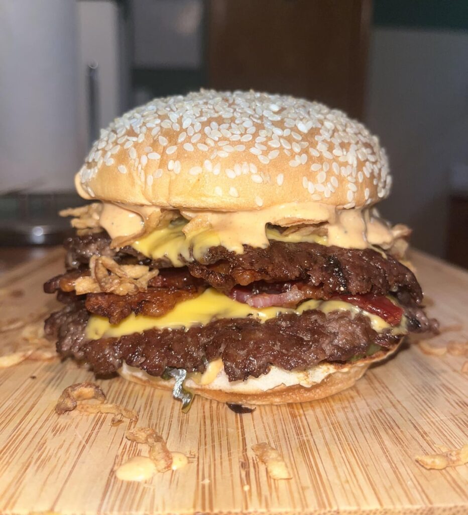 Bacon, American cheese, bread and butter pickles, crispy onions, and homemade sauce. 80/20 ground chuck. Martins bun. Meat seasoned with Lawry’s seasoned salt and pepper.