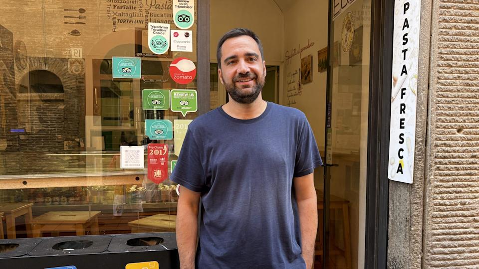 a man stands in front of a pasta shop