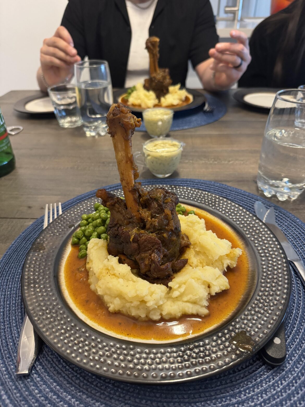 Apricot braised lamb shank with golden butter mash potatoes and peas.
