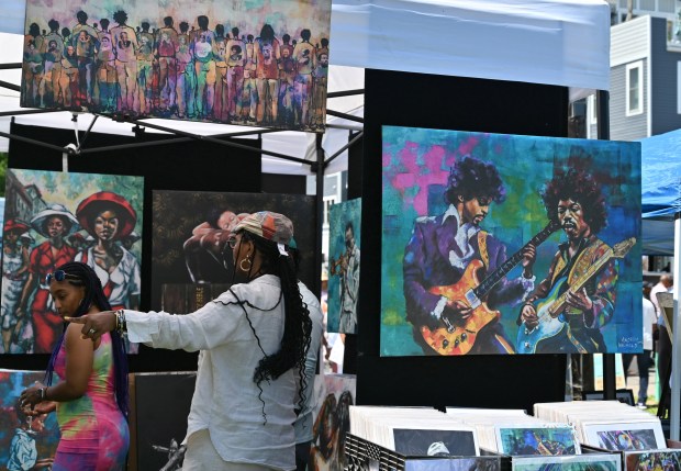 People check out the works of a artist at the vendor booth during the Arts, Wine, Jazz & Soul Festival in Havre de Grace on Saturday. Proceeds from the event benefit the Havre de Grace Colored School Foundation. (Brian Krista/Staff)