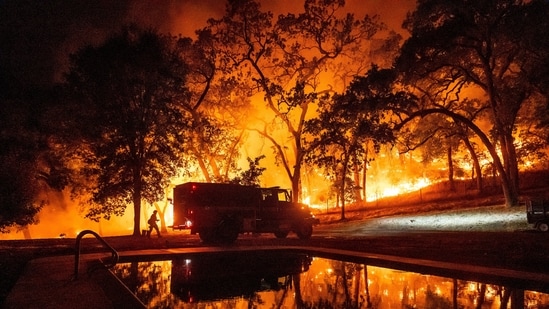 Surrounded by flames, a fire truck stands at the center as firefighters battle the spreading blaze. (AP Photo/Noah Berger)(AP)