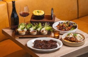 Assorted platters of food and a glass of wine at BRBQ at Journal Square Urby in Jersey City