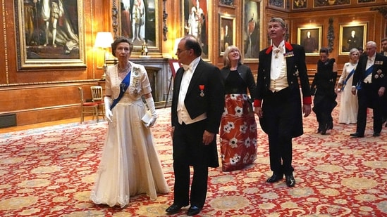 Britain's Princess Anne, Princess Royal (L) and Secretary General of the French Presidency Emmanuel Moulin (C) arrive to attend a State Banquet at Windsor Castle, west of London.(AFP)