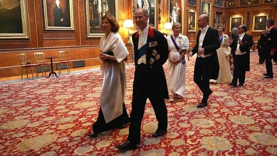 France's Ambassador to the United Kingdom Helene Duchene (L) and Britain's Prince Edward, Duke of Edinburgh arrive to attend a State Banquet at Windsor Castle, west of London.(AFP)