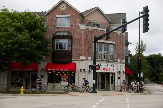 Kids ride bikes in front of the new Oberweis Dairy in Winnetka on Aug. 20, 2025, before the store's soft opening in the afternoon. (Eileen T. Meslar/Chicago Tribune)