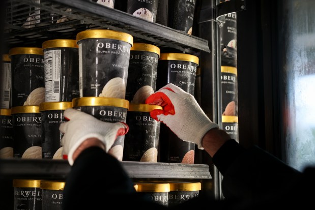 Assistant Manager Conor O'Keeffe places containers of Oberweis ice cream in a freezer before the soft opening in the afternoon of the new Oberweis Dairy store in Winnetka on Aug. 20, 2025. (Eileen T. Meslar/Chicago Tribune)