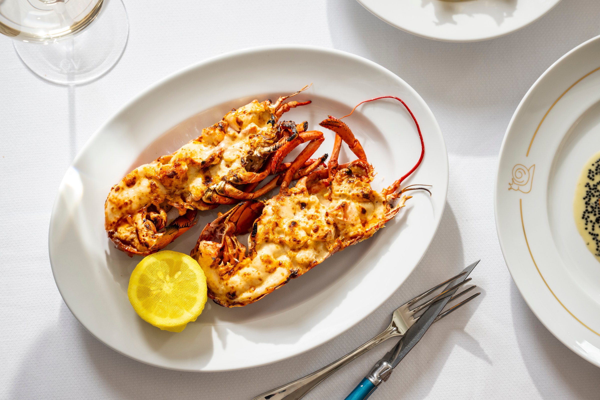 A plate of halved lobster with a lemon.