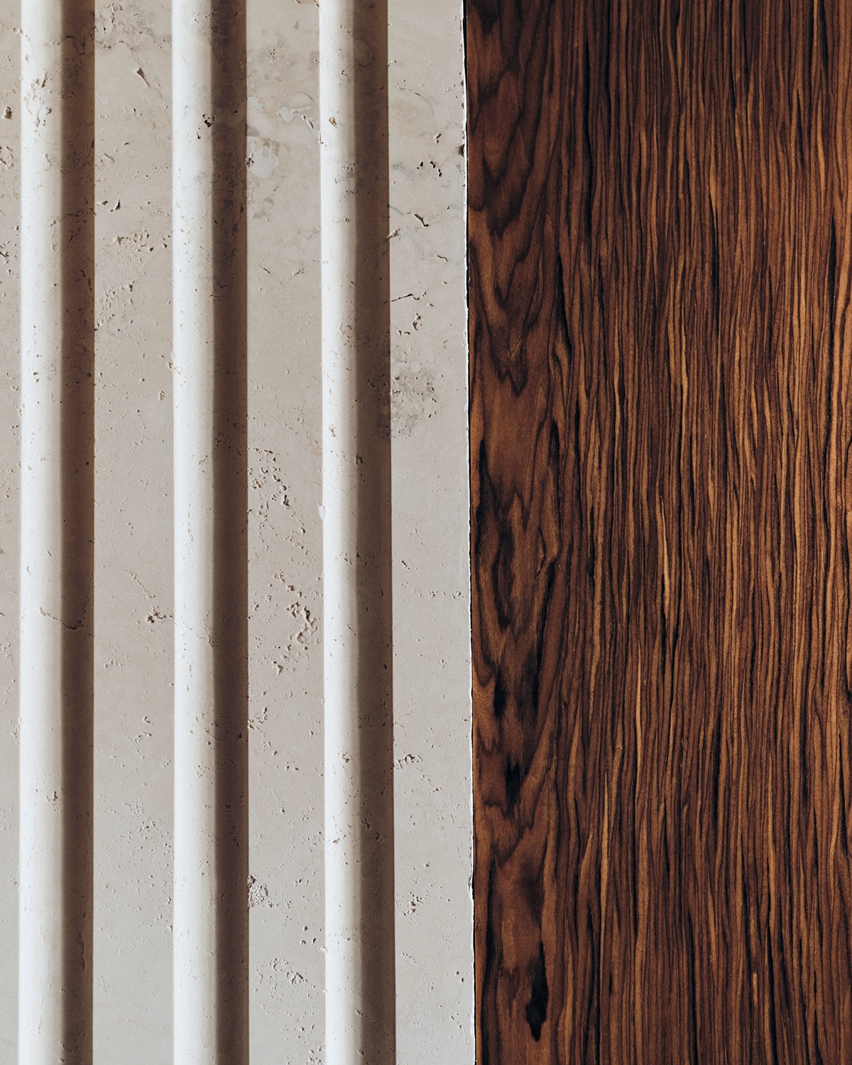 Contrasting textures of travertine and rich wood create a refined statement at W Rome