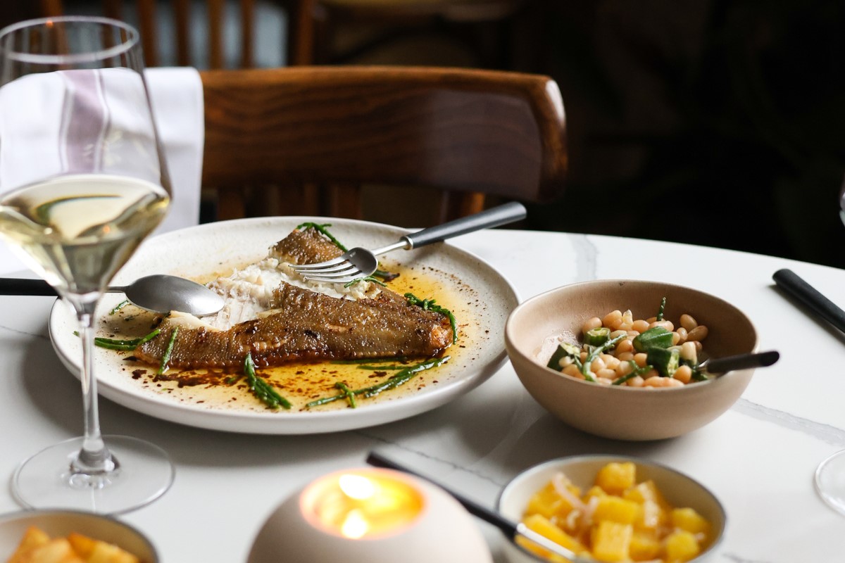 a selection of food placed on a table, with a fish dish at the centre of it all