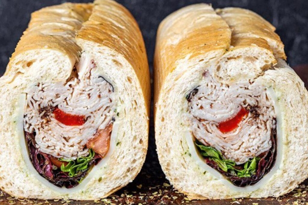 Image shows the Sophia sandwich at Tony's Italian Delicatessen in Houston featuring roasted turkey, roma tomatoes, and a spring mix on an Italian roll.