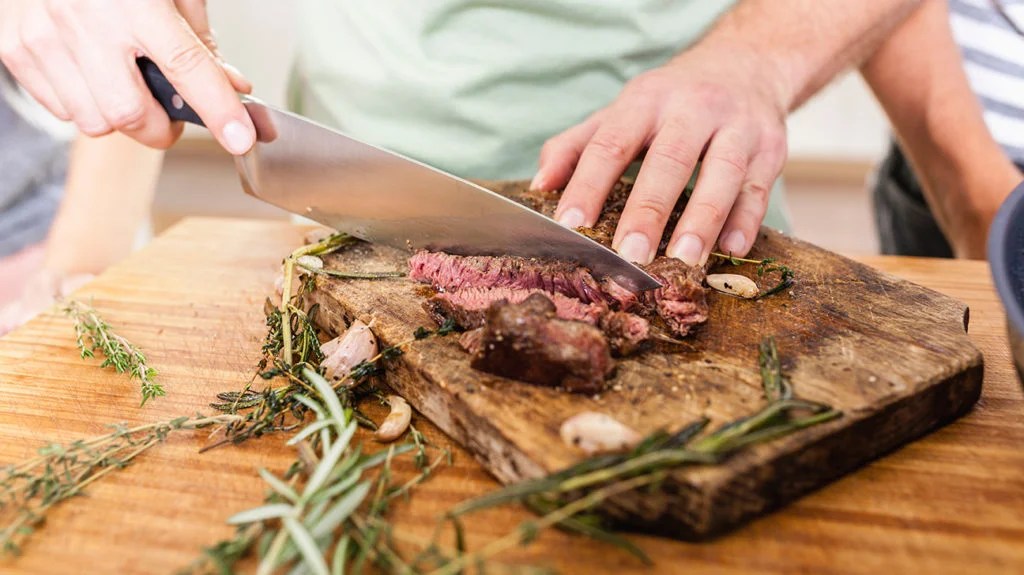 a man cut meat that he is going to eat as part of his dukan diet