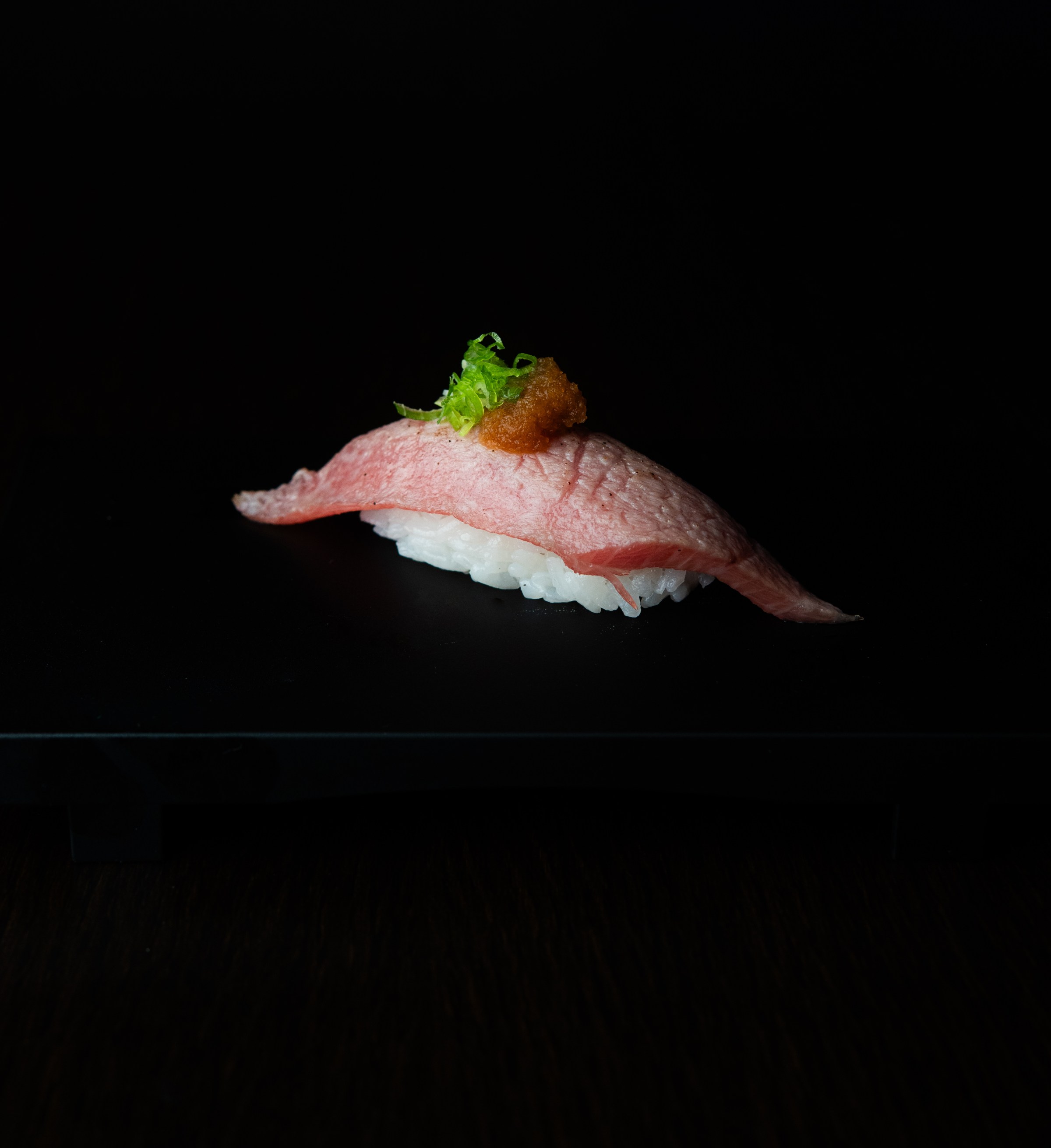 Tuna nigiri on a black background from Sushi Zanmai