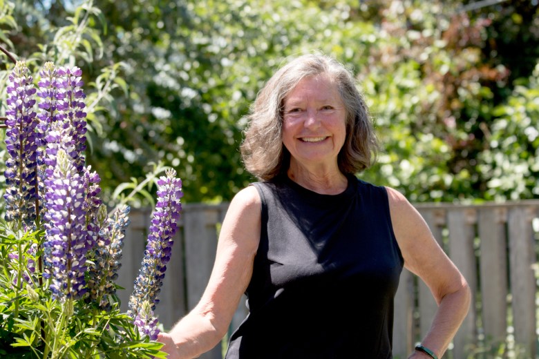 Jan Roberts-Dominguez in her backyard with lupines