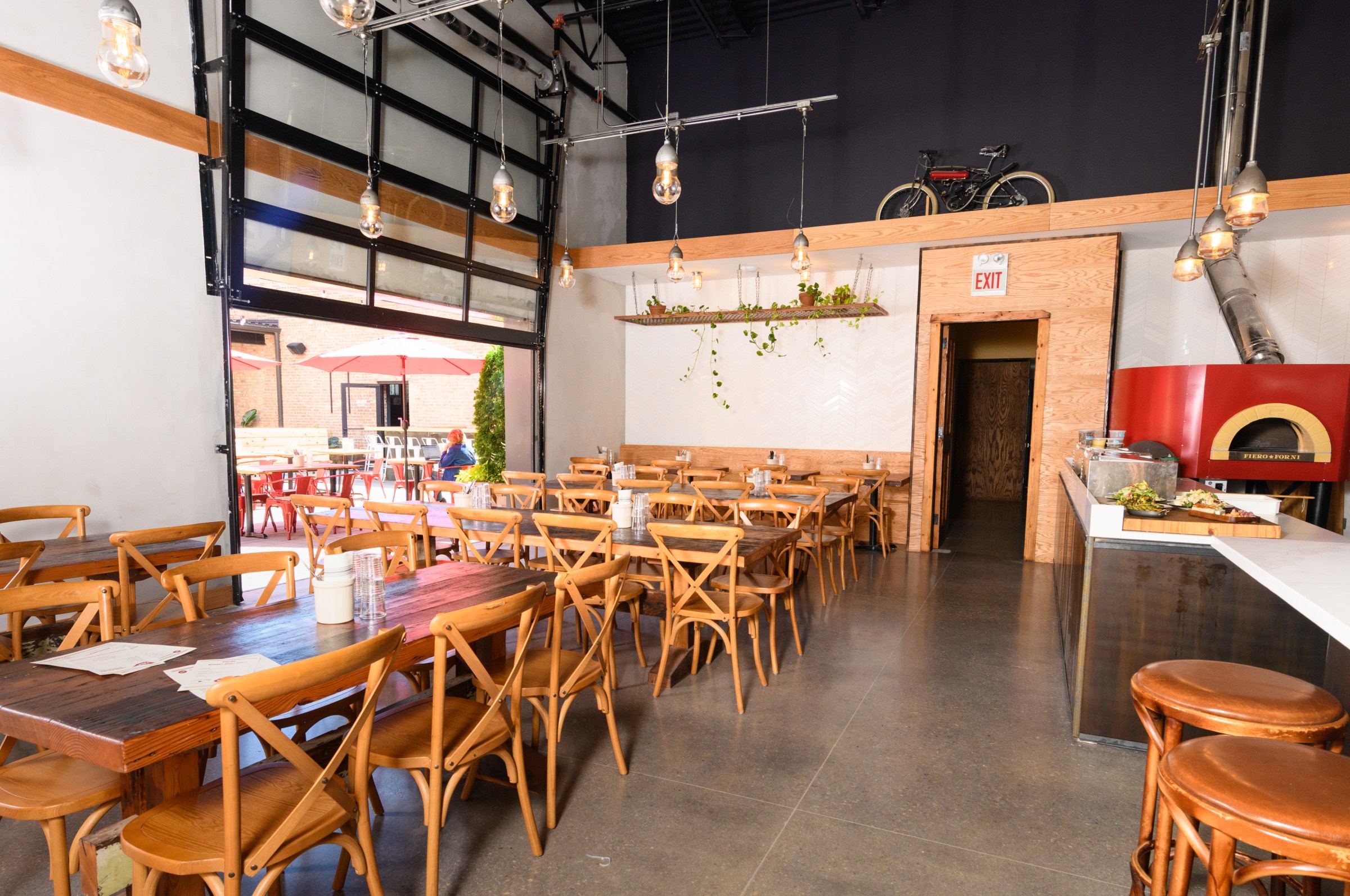 An opening dining room with garage doors that open out onto a courtyard.