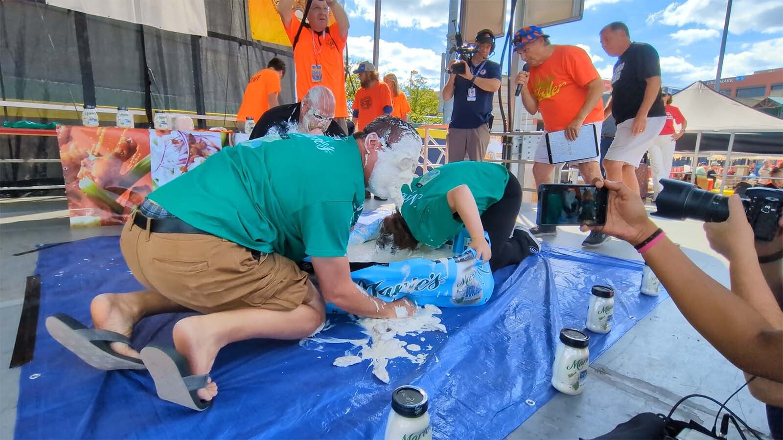 Andrew Beglin, left, emerged as the winner of the “Bobbing for Wings Contest,” and successfully found 20 chicken wings in a kiddie pool filled with bleu cheese while wearing swim goggles.