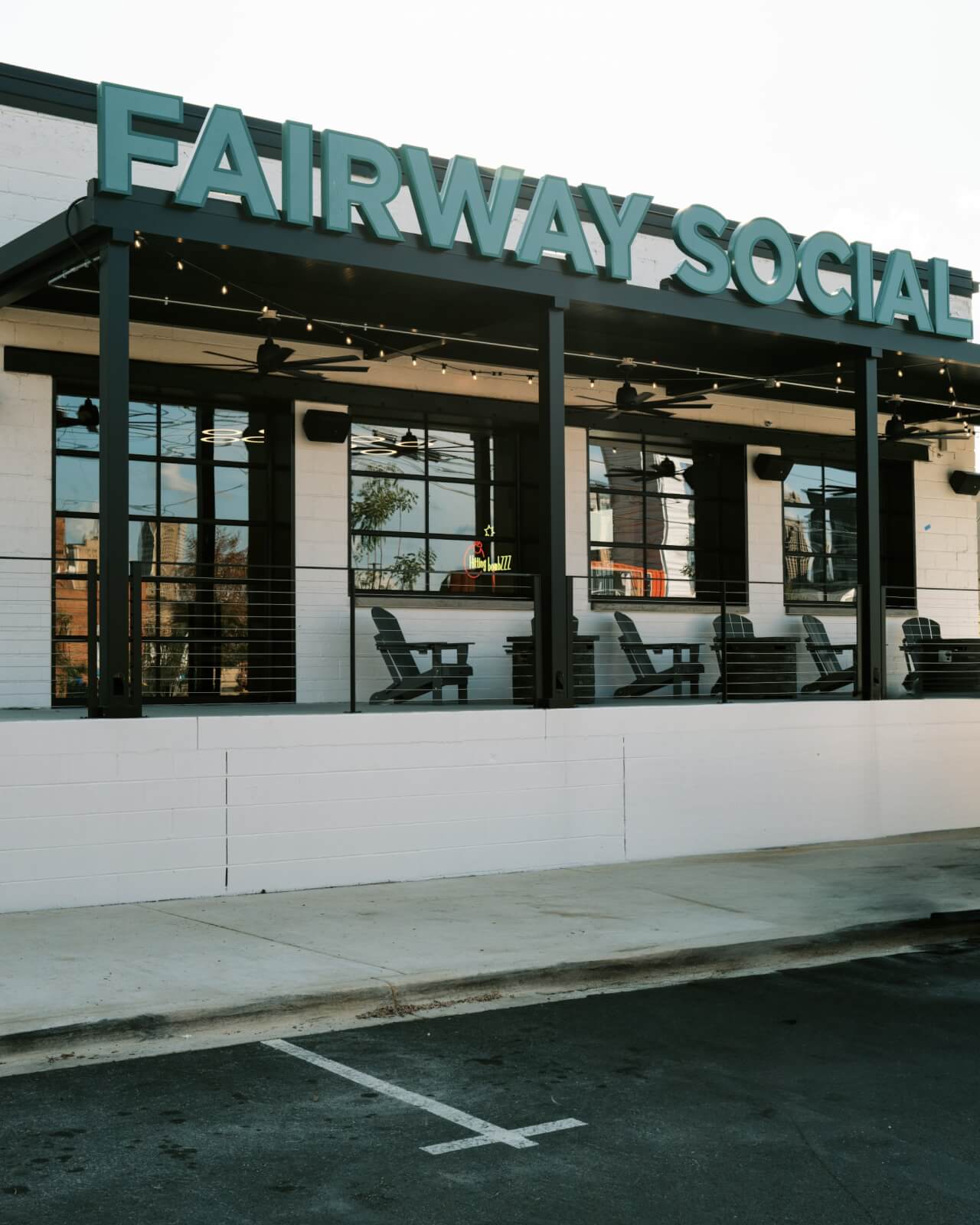 Outdoor view of the Fairway Social building with patio seating and a large sign above the entrance, showcasing one of the exciting new restaurant concepts in Birmingham restaurants.