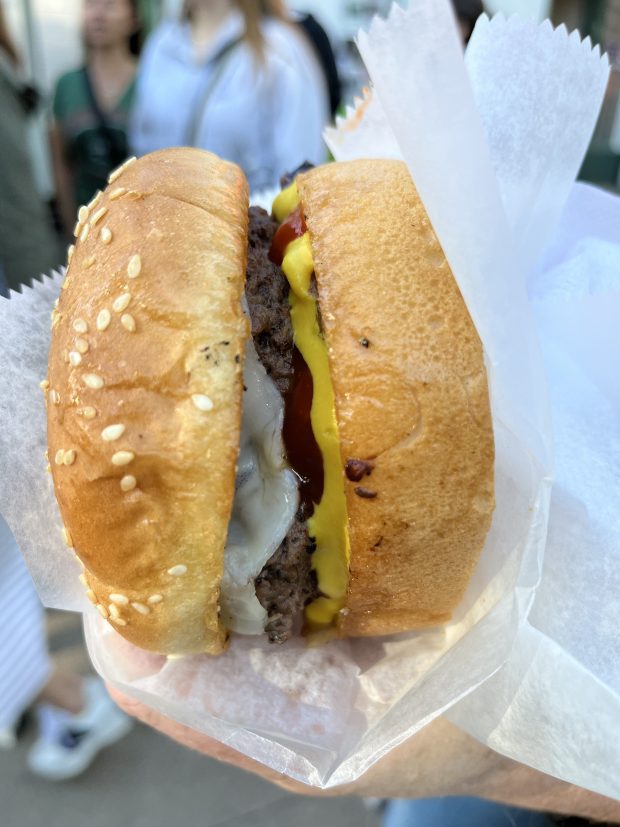 A burger with cheese, ketchup and mustard