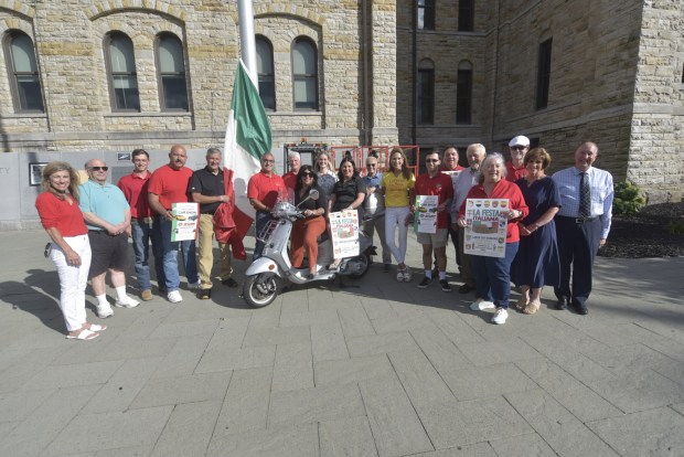 Some of the board members, committee volunteers and civic officials associated with La Festa Italiana raise the Italian flag on Courthouse Square in downtown Scranton, site of the festival to be held this weekend, beginning Friday. From left: Ann DiMattio, Tony Nicosia, Louis DiMattio, Marc Pane, Lackawanna County Commissioner Chris Chermak, Joe Guido, La Festa President Chris DiMattio, Francene Pisano, Scranton Mayor Paige Gephardt Cognetti, Debra Meila, Frank Gervasi, Leslie Minicozzi Galacci, Alex Strubeck, attorney Frank T. Blasi, Robert W. Pettinato, Karen Clifford, Bill Genello, Diane Alberigi, and attorney Frank Castellano. (CHAD SEBRING/STAFF PHOTO)