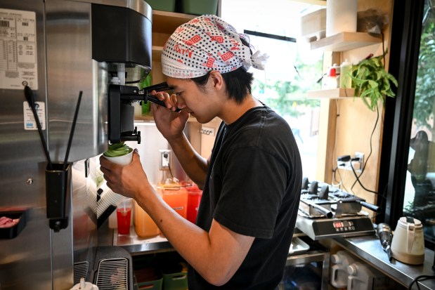 William Nasanjargal pours a cup of soft serve ice cream at Ichigo Matcha in on the 16th Street Mall in Denver on Tuesday, Aug. 26, 2025. (Photo by AAron Ontiveroz/The Denver Post)