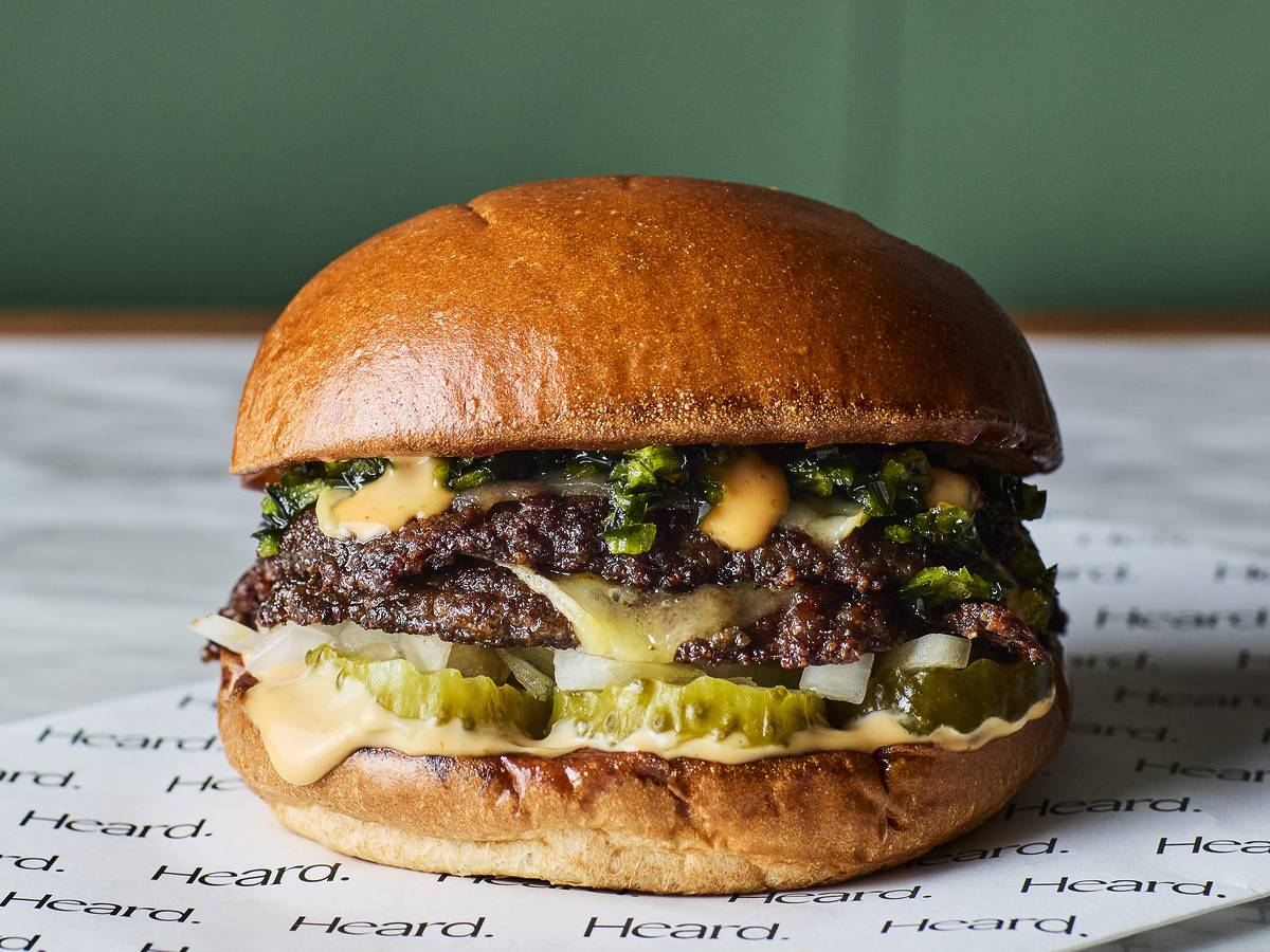 a burger from heard topped with pickles and jalapenos