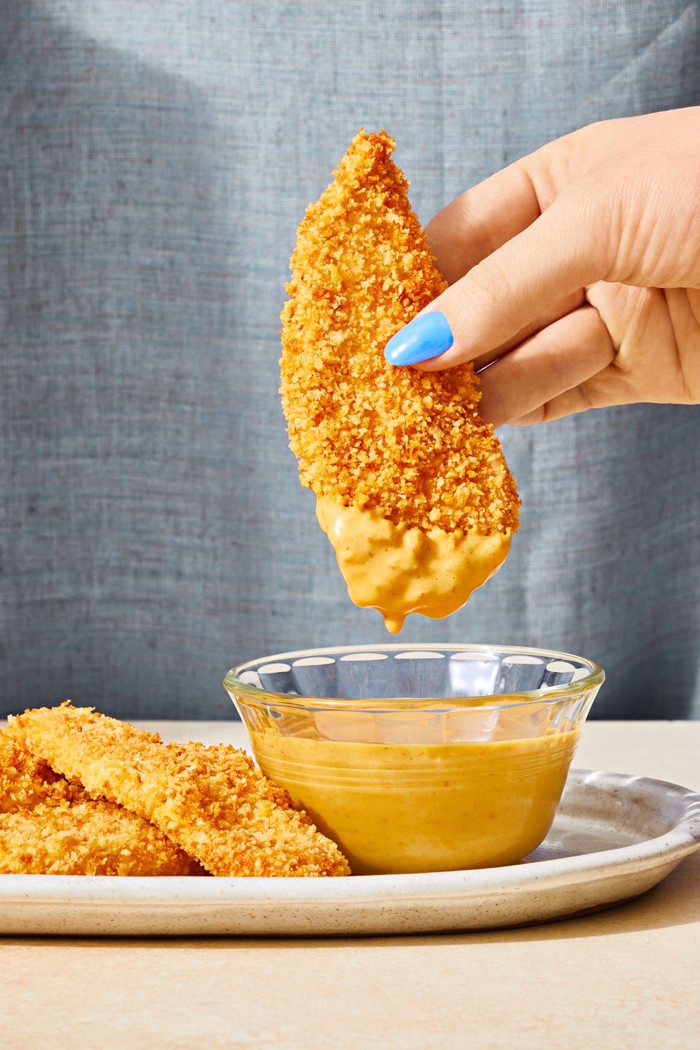 breaded chicken strips dipped in yellow sauce
