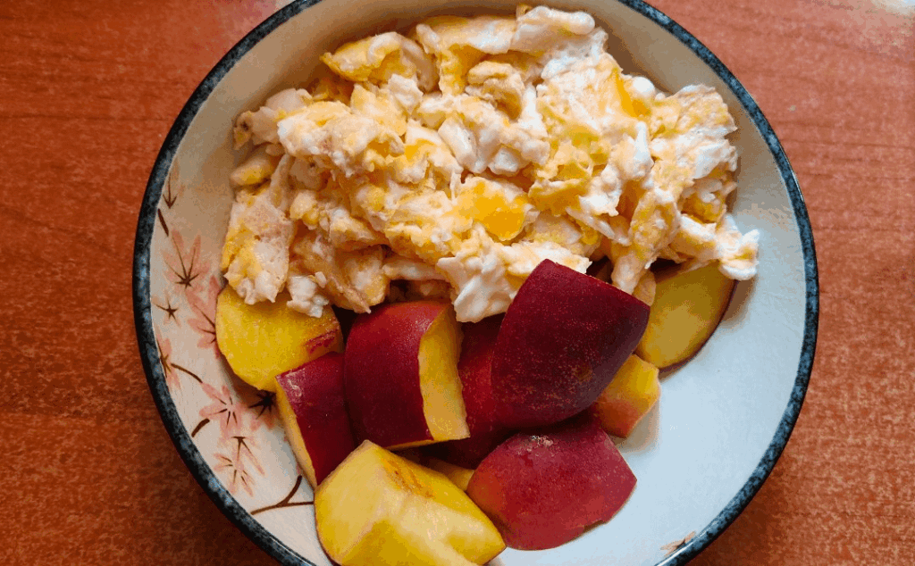 Breakfast, scrambled eggs and nectarine