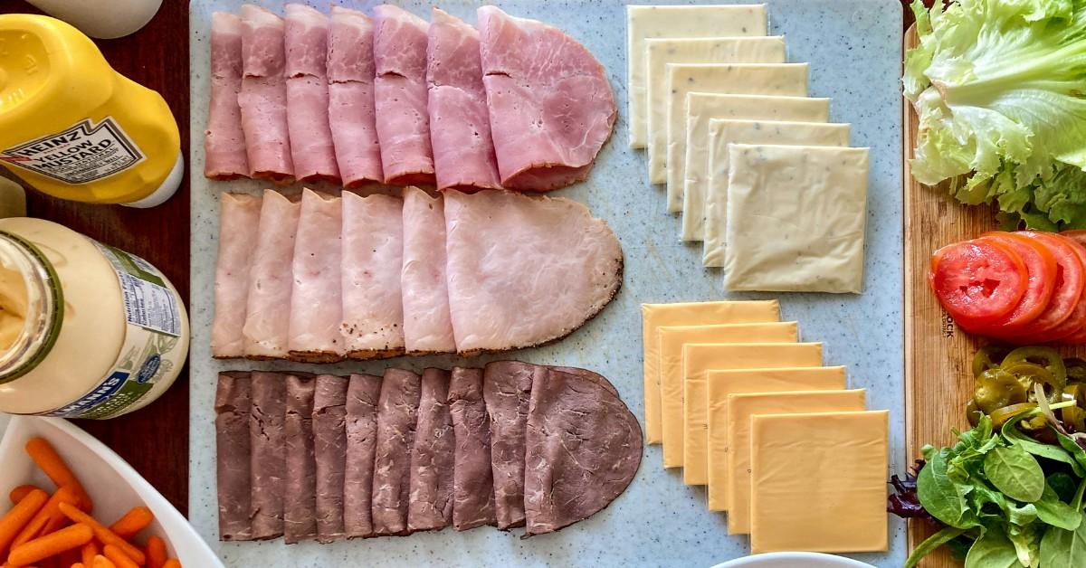 An overhead view of a tray of lunch meats and cheeses