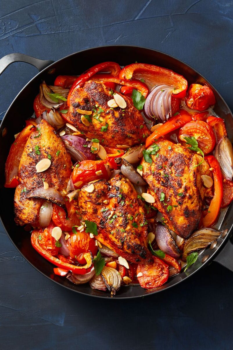 chicken with stewed peppers and tomatoes on a skillet