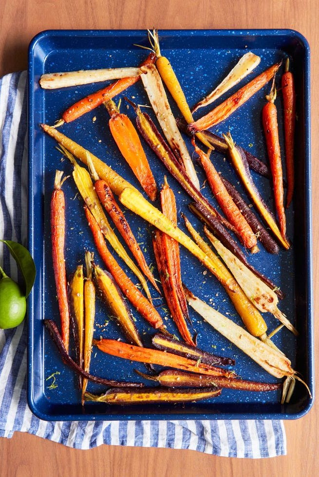 coriander maple glazed carrots on a blue sheet pan