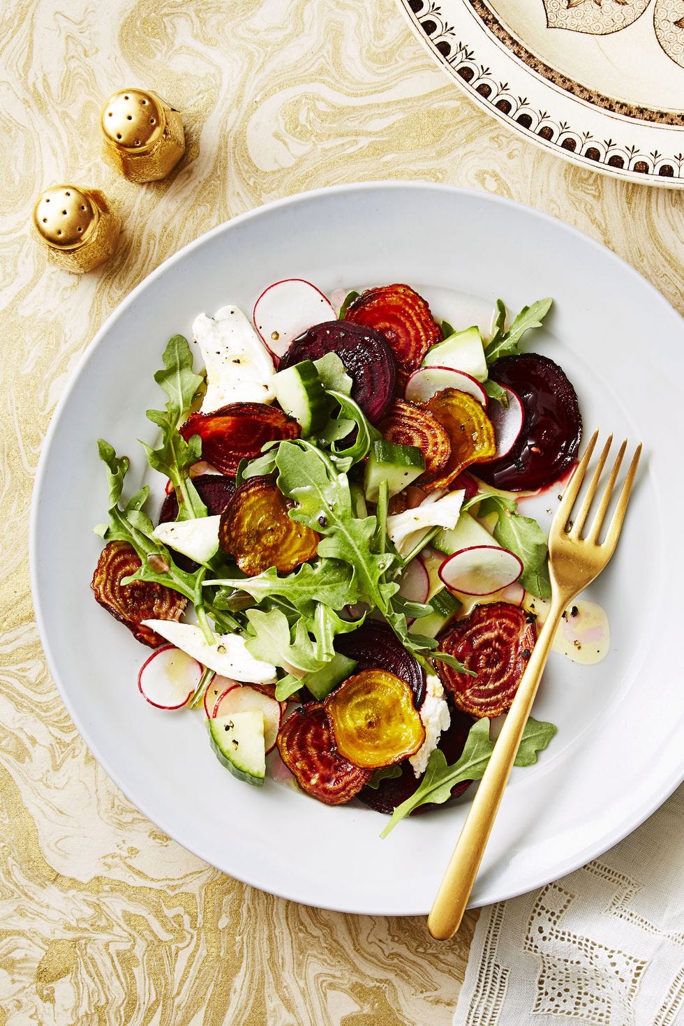 beet, cucumber and arugula salad on a white plate