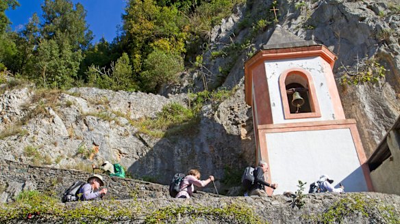 Hiking past a cliffside chapel at Papasidero in the Lao River gorge.